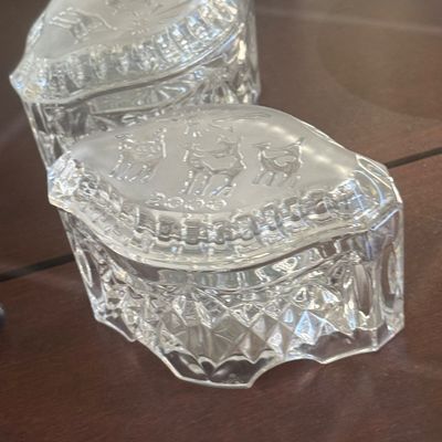 Sale Photo Thumbnail #122: Pair of vintage crystal trinket boxes featuring frosted lids embossed with reindeer scenes and diamond-cut bases.
