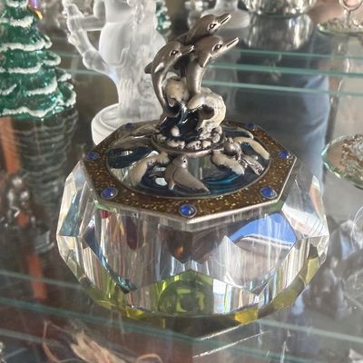 Sale Photo Thumbnail #135: Ornate crystal trinket dish with a pewter lid featuring jumping dolphins and faux sapphire accents.