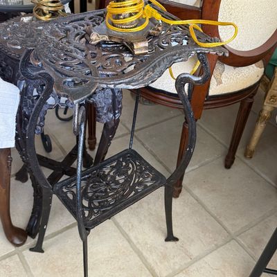Sale Photo Thumbnail #66: Ornate black cast iron two-tier plant stand featuring intricate scrollwork and floral motifs.