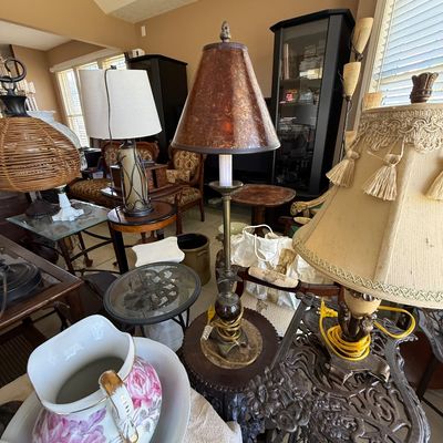 Sale Photo Thumbnail #64: Collection of traditional home furnishings including a metal candlestick table lamp with mottled shade, a fringe-trimmed shade table lamp, a floral wash basin set, and various accent tables.