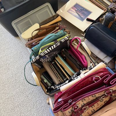 Sale Photo Thumbnail #22: Large collection of women's handbags, purses, and wallets organized in plastic storage bins alongside framed artwork and shoes.