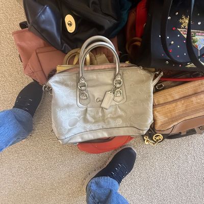 Sale Photo Thumbnail #165: Collection of women's designer and fashion handbags, including a metallic silver Coach monogram satchel, a Michael Kors shoulder bag, and various leather totes.