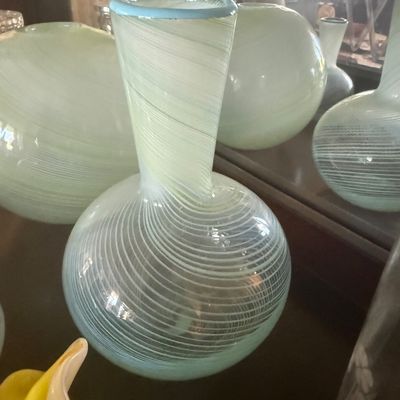 Sale Photo Thumbnail #103: Hand-blown swirl glass vase featuring a light blue rim and delicate white filigree line patterns, accompanied by matching art glass pieces.