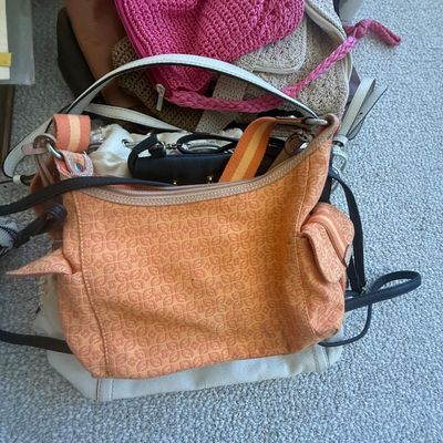 Sale Photo Thumbnail #182: Collection of assorted women's handbags and shoulder bags, featuring a patterned orange Fossil purse, knit totes, and leather bags.
