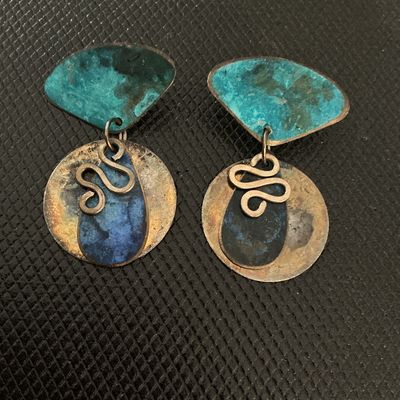 Sale Photo Thumbnail #213: Pair of vintage artisan drop earrings featuring mixed metal components with blue and teal enamel patinated finishes, squiggly wire accents, and geometric shapes. Shows light tarnish and age-appropriate wear.