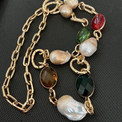Sale Photo Thumbnail #138: Gold-tone chain station necklace featuring large, irregularly shaped baroque pearls interspersed with faceted oval crystals in red, green, amber, and dark green. The necklace combines a paperclip link chain with textured circular accent links. Good pre-ow