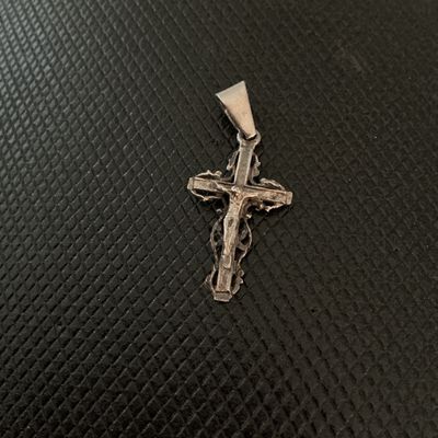 Sale Photo Thumbnail #140: Ornate sterling silver crucifix cross pendant featuring intricate filigree work around the edges and a bail stamped '925'. Shows light vintage patina and wear consistent with age and use.