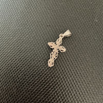 Sale Photo Thumbnail #141: Ornate sterling silver crucifix cross pendant featuring intricate filigree work around the edges and a bail stamped '925'. Shows light vintage patina and wear consistent with age and use.