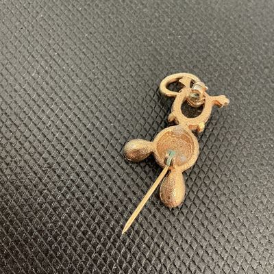 Sale Photo Thumbnail #224: Charming vintage gold-tone mouse brooch featuring a textured head, black cabochon stone body, small black eye detail, and a curved tail. C-clasp fastener on the back shows minor verdigris/patina near the pin stem hinge, otherwise in good condition with li