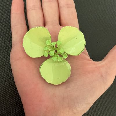 Sale Photo Thumbnail #175: Vintage light green/chartreuse enamel flower brooch pin featuring three large petals and detailed center stamen. Back side shows a standard pin stem and clasp mechanisms along with light wear and paint loss to the reverse finish. Measures approximately 2.
