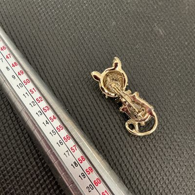 Sale Photo Thumbnail #203: A charming vintage gold-tone cat brooch featuring a textured finish, a bright blue cabochon body, and a blue rhinestone eye. Measures approximately 1.5 inches in length. In good vintage condition with minor wear consistent with age. Pin back fastener is f