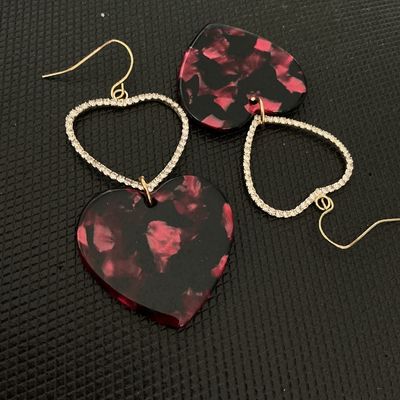 Sale Photo Thumbnail #230: Pair of statement dangle earrings featuring double heart design. Includes a rhinestone-encrusted open heart top piece with a dark pink and black mottled tortoiseshell pattern acrylic heart drop. Fitted with gold-tone wire ear hooks. Good condition with al