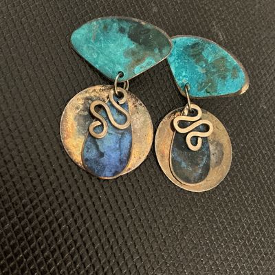 Sale Photo Thumbnail #214: Pair of vintage artisan drop earrings featuring mixed metal components with blue and teal enamel patinated finishes, squiggly wire accents, and geometric shapes. Shows light tarnish and age-appropriate wear.