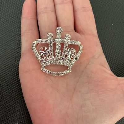 Sale Photo Thumbnail #182: A sparkling crown-shaped brooch featuring round and marquise-cut clear rhinestones set in silver-tone metal. Good condition with all stones intact and a secure pin back mechanism.
