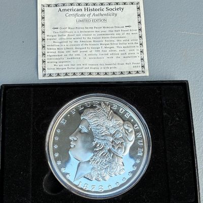 Sale Photo Thumbnail #78: American Historic Society Giant Half Pound Silver Proof Morgan Dollar medallion in display box with original Certificate of Authenticity.