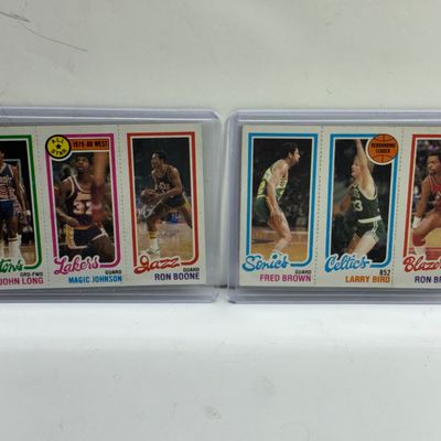 Sale Photo Thumbnail #89: Pair of 1980-81 Topps NBA basketball scoring leader rookie cards featuring Magic Johnson and Larry Bird, both encased in protective plastic sleeves.