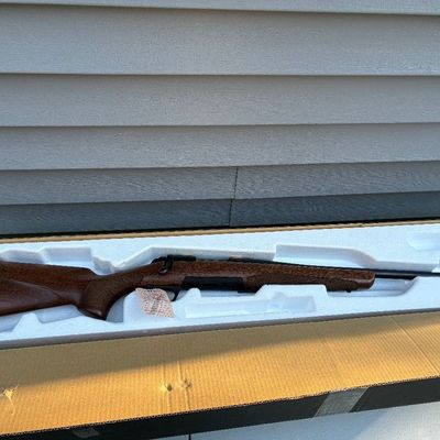 Sale Photo Thumbnail #58: Bolt-action hunting rifle with a wood stock in its original factory box with styrofoam insert.
