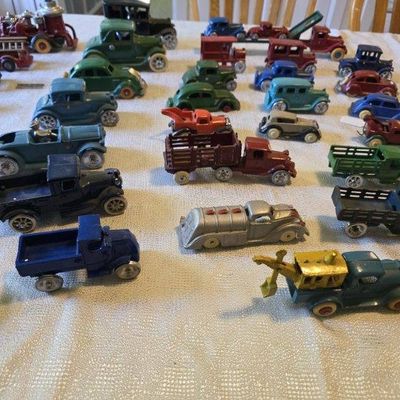 Sale Photo Thumbnail #50: Large collection of vintage die-cast metal toy vehicles, including trucks, cars, and construction equipment from the 1930s to 1950s.
