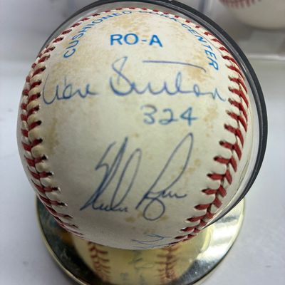Sale Photo Thumbnail #100: Autographed Don Sutton official baseball featuring blue ink signatures and '324' inscription, housed in a clear protective display case.