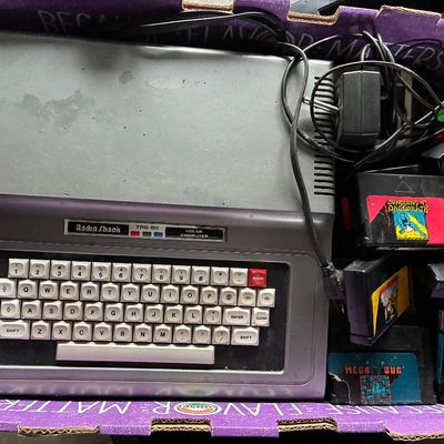 Sale Photo Thumbnail #115: Vintage Radio Shack TRS-80 Color Computer with power adapter and a collection of program cartridges, including Dungeons of Daggorath and Mega-Bug.