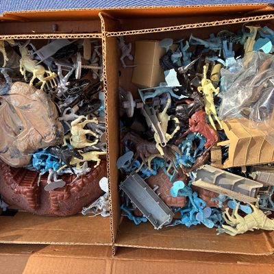 Sale Photo Thumbnail #7: Cardboard box filled with vintage plastic toy soldiers, horses, cannons, and play set terrain pieces.