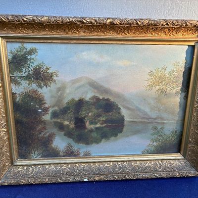 Sale Photo Thumbnail #33: Antique landscape painting depicting a mountain lake with an island, housed in an ornate gilded gesso wood frame.