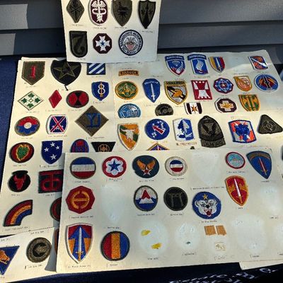 Sale Photo Thumbnail #9: Collection of mid-20th-century U.S. military insignia and unit shoulder sleeve patches mounted on display boards.