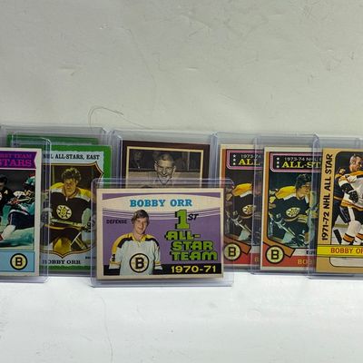 Sale Photo Thumbnail #85: Collection of vintage Bobby Orr Topps and O-Pee-Chee hockey trading cards from the 1970s in protective top loaders.