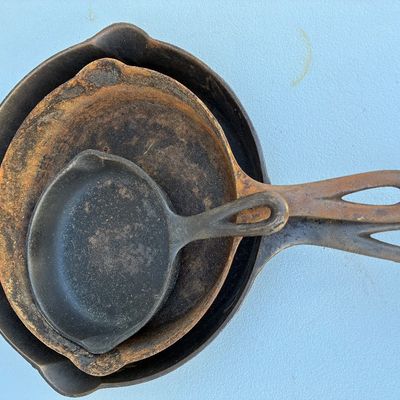 Sale Photo Thumbnail #126: Set of three vintage cast iron skillets in graduated sizes, showing surface rust and wear consistent with age and use.