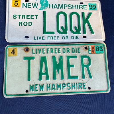 Sale Photo Thumbnail #32: Pair of vintage New Hampshire personalized license plates, including a 1999 Street Rod plate reading "LOOK" and a 1983 plate reading "TAMER", showing light wear and surface aging.