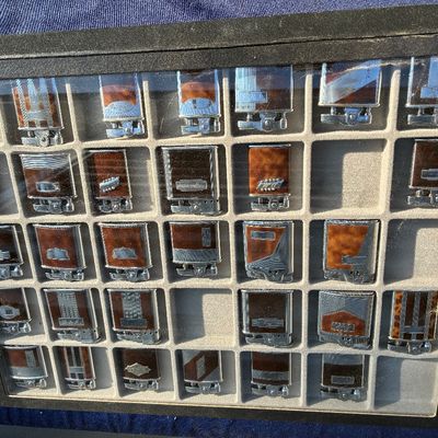 Sale Photo Thumbnail #27: Collection of vintage Art Deco style pocket lighters displayed in a black framed shadowbox case with a divided felt tray.