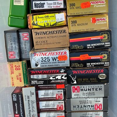 Sale Photo Thumbnail #79: Assorted collection of vintage and modern rifle and handgun ammunition boxes, including brands like Winchester, Hornady, Nosler, and Federal in various calibers.