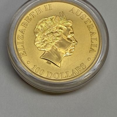 Sale Photo Thumbnail #40: Australian Queen Elizabeth II 100-dollar gold bullion coin, housed in a protective clear plastic capsule.
