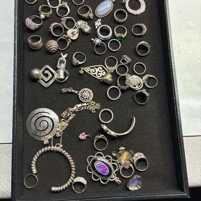 Sale Photo Thumbnail #118: Black display tray filled with assorted sterling silver and costume jewelry, including gemstone rings, pendants, and cuffs.