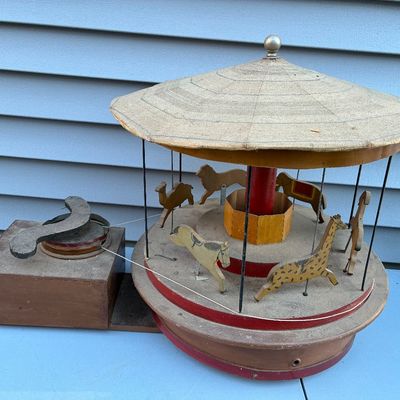 Sale Photo Thumbnail #112: Vintage wind-up mechanical carousel toy featuring carved wooden animals and a string-pulley motor drive.