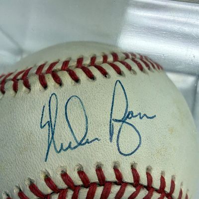 Sale Photo Thumbnail #104: Autographed baseball signed in blue ink, housed in a protective clear acrylic display case.
