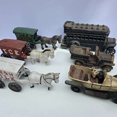 Sale Photo Thumbnail #52: Collection of six vintage cast iron toy vehicles, including horse-drawn wagons and early 20th-century style automobiles.