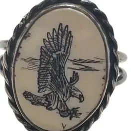 Vintage scrimshaw ring featuring an etched soaring eagle set in a sterling silver twisted rope frame.