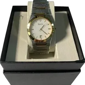 Two-tone Bulova wrist watch with a white dial and date window, displayed in its original presentation box.