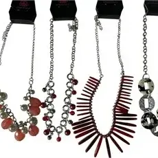Set of four modern Paparazzi costume necklaces attached to display cards, including beaded strand, fringe, and linked ring statement...
