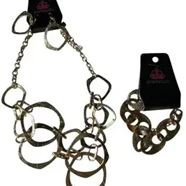 Paparazzi branded costume jewelry set featuring a gold-tone statement necklace with matching drop earrings and a coordinating link...