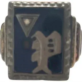 Vintage signet-style ring featuring a dark inset face with silver-tone symbols and a textured rectangular border.