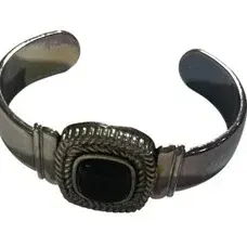 Silver-tone cuff bracelet featuring a square black cabochon stone set in a rope-textured bezel.
