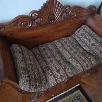 Sale Photo Thumbnail #3: Antique carved wooden settee featuring a detailed shell crest and scroll arms, fitted with a patterned tapestry seat cushion.