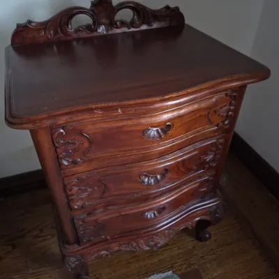 Sale Photo Thumbnail #34: Vintage French Provincial style mahogany nightstand featuring three carved drawers, a serpentine front, and a decorative carved crest.