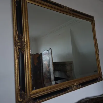 Sale Photo Thumbnail #18: Large ornate rectangular wall mirror featuring a gilt frame with black inner trim and decorative corner carvings.