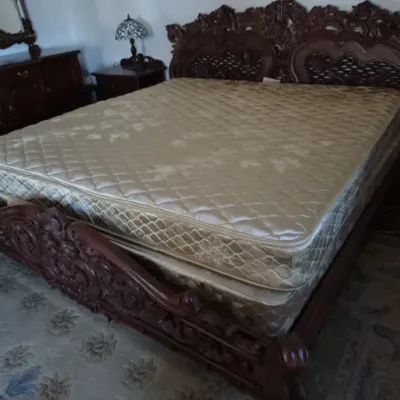 Sale Photo Thumbnail #54: Ornately carved dark wood king bed frame with an elaborate headboard and footboard, complete with mattress set.