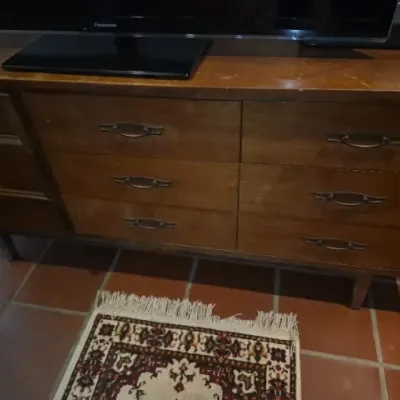 Sale Photo Thumbnail #55: Mid-century modern wooden dresser featuring decorative metal hardware, angled legs, and light surface wear.