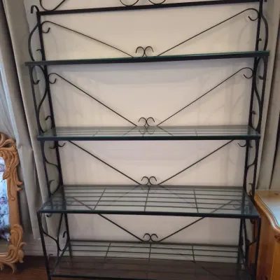 Sale Photo Thumbnail #40: Black wrought iron baker's rack featuring decorative scrollwork arches and four glass shelf inserts.