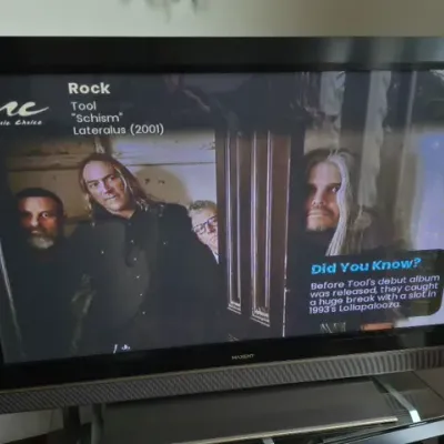Sale Photo Thumbnail #64: Maxent flat screen television displayed on a glass TV stand, showing a Music Choice cable channel screen.